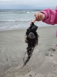 Person holding umbrella on beach