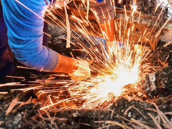 Low angle view of man working on metal