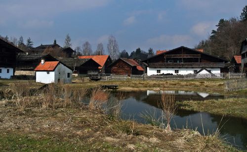 Houses by water against sky