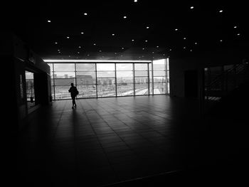 Full length of woman walking through dark corridor