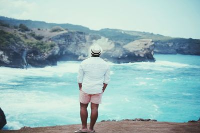 Rear view full length of man standing at beach