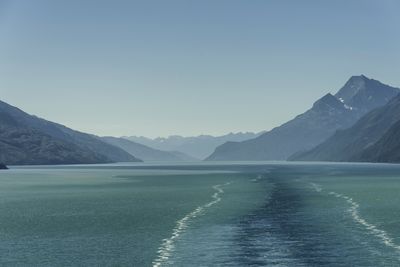 Scenic view of lake and mountains against clear blue sky