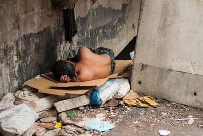 High angle view of man sleeping on wall