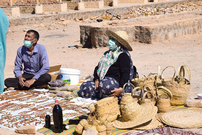 Rear view of a man and a woman selling mat-weaver handicrafts