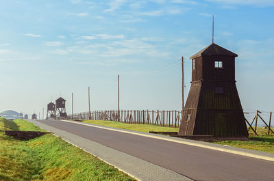 Empty road by bridge against sky