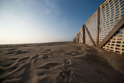 Surface level of sand at beach against sky