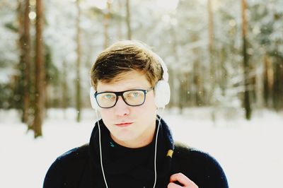 Portrait of man listening music in snow