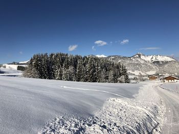 View of snow covered landscape against blue sky