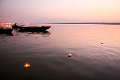 High angle view of illuminated diyas on ganges river during sunrise