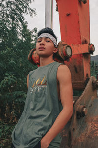 Full length of boy looking away while standing against trees