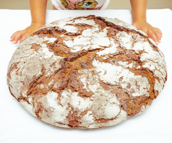 Midsection of person with bread on table