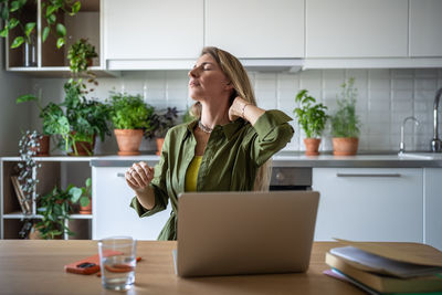 Young woman using laptop while sitting at office