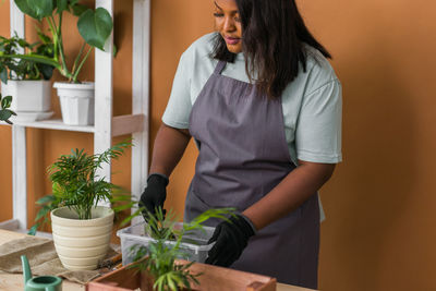 Midsection of young woman holding potted plant