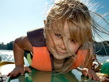 Portrait of girl holding paddleboard in sea