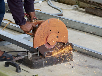 Low section of man working on metal