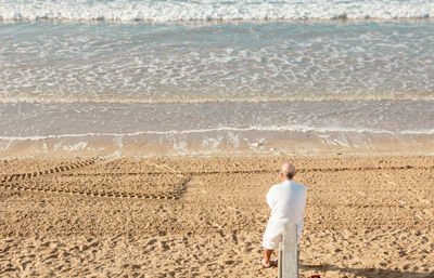 Lonely man in bathrobe on the beach in the morning at les sables d'olonnes in summer