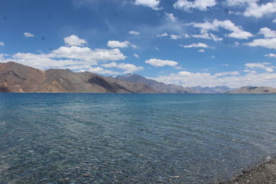 Scenic view of sea and mountains against sky