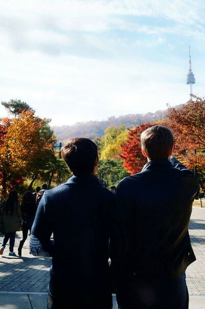 REAR VIEW OF PEOPLE STANDING IN CITY