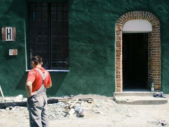 Rear view of woman standing in front of building