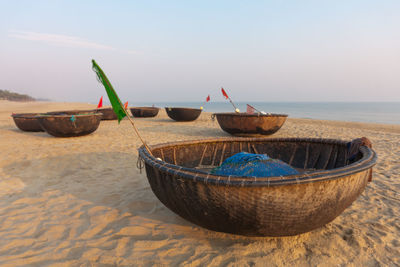 Deck chairs on beach against sky