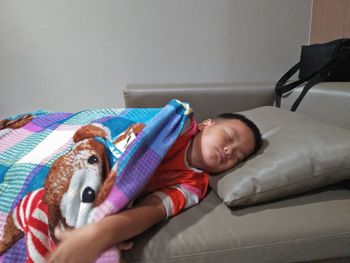Cute boy sleeping on bed at home