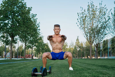 Portrait of shirtless man exercising in gym