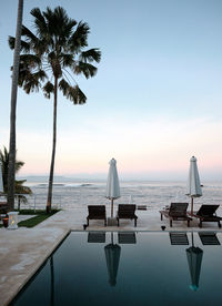 Still pool and deckchairs at a luxury resort at sunset 