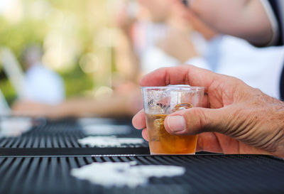 Cropped image of man holding tequila shot