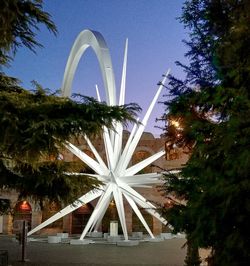 Illuminated ferris wheel against sky at night