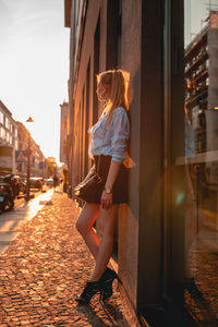 Side view of woman walking on footpath in city