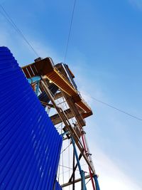 Low angle view of communications tower against blue sky