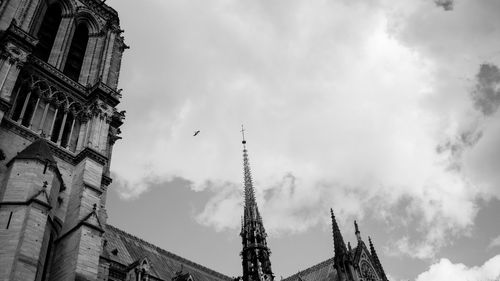 Low angle view of clock tower against cloudy sky