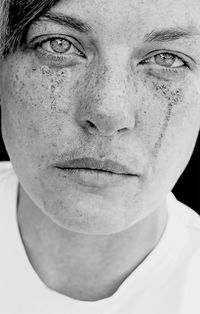 Close-up portrait of woman with freckles on face