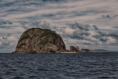 Scenic view of rock formation in sea against sky