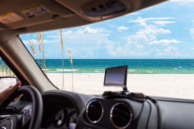 Vintage car on beach seen through window