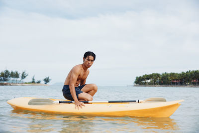 Portrait of shirtless man swimming in sea