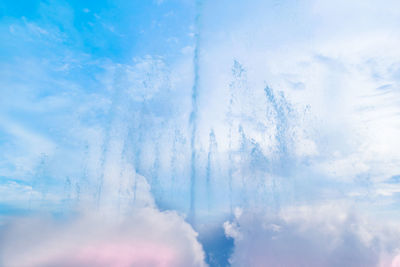 Low angle view of sunlight streaming through clouds in sky