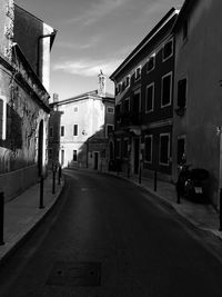 Empty road amidst buildings in city