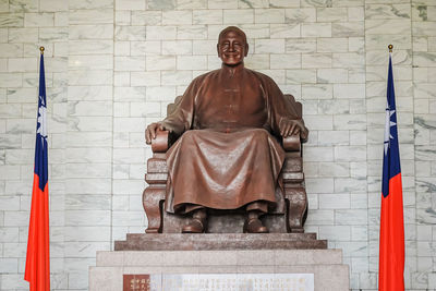 Portrait of buddha statue against building