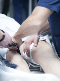 Midsection of doctors operating patient in hospital