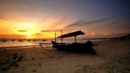 Scenic view of sea with local fisherman boat against sky during sunset