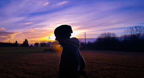 Rear view of a man standing on landscape against sky