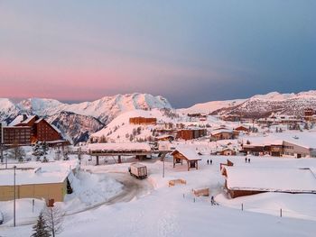 Houses on snow covered mountain against sky