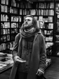 Portrait of young mann standing in library