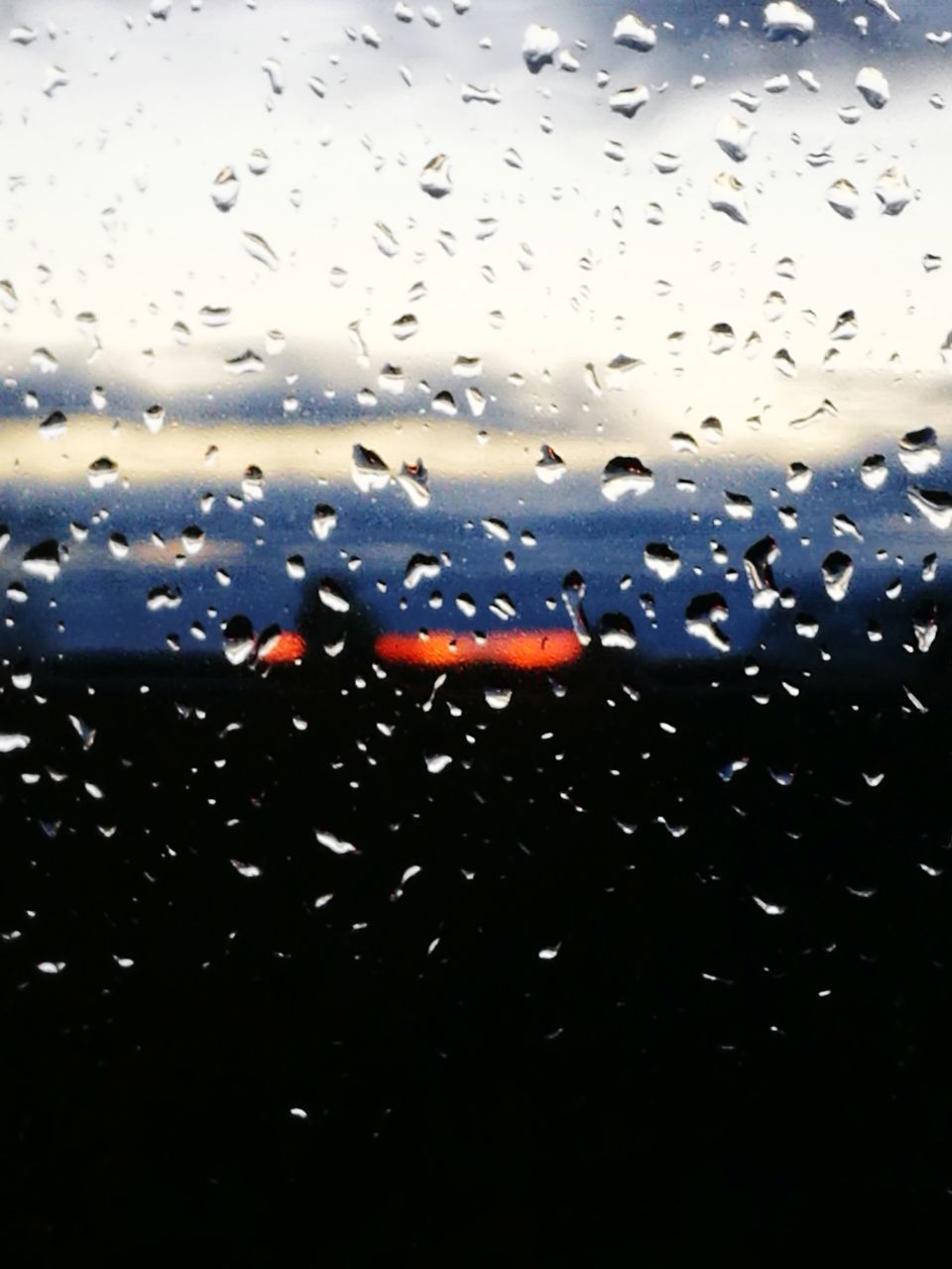 CLOSE-UP OF RAINDROPS ON GLASS WINDOW