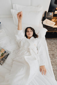 Portrait of woman lying on bed at a hotel