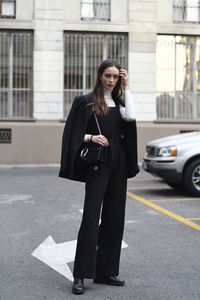 Full length of woman standing on road in city