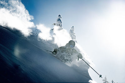 Low angle view of person skiing on mountain against sky