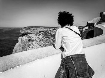 Rear view of woman looking at sea against sky