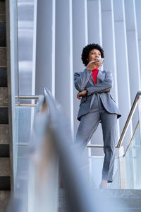 A young african-american businesswoman wearing a red turtleneck and a suit in a business building